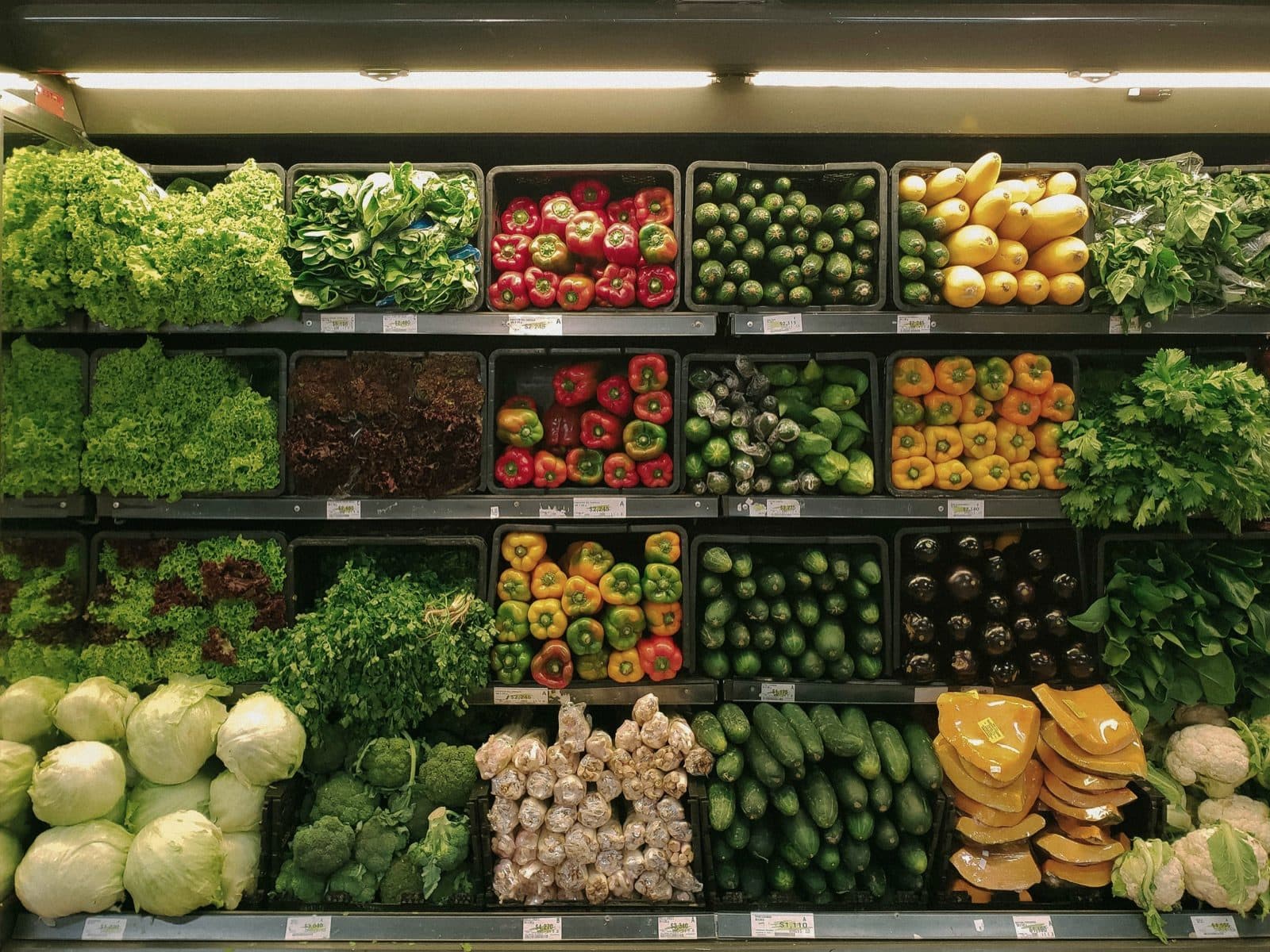 Schappen vol verse groente in een winkel